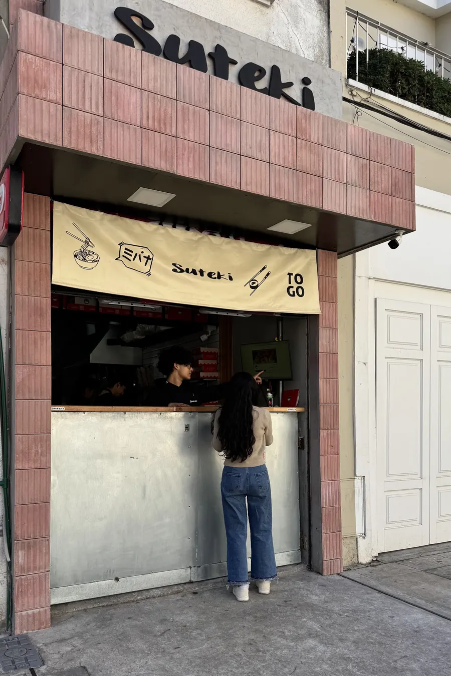 Fachada de Suteki Pocitos, con el cartel y la ventana de take away