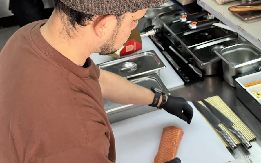 Cocinero de Suteki cortando salmón en la cocina de Pocitos
