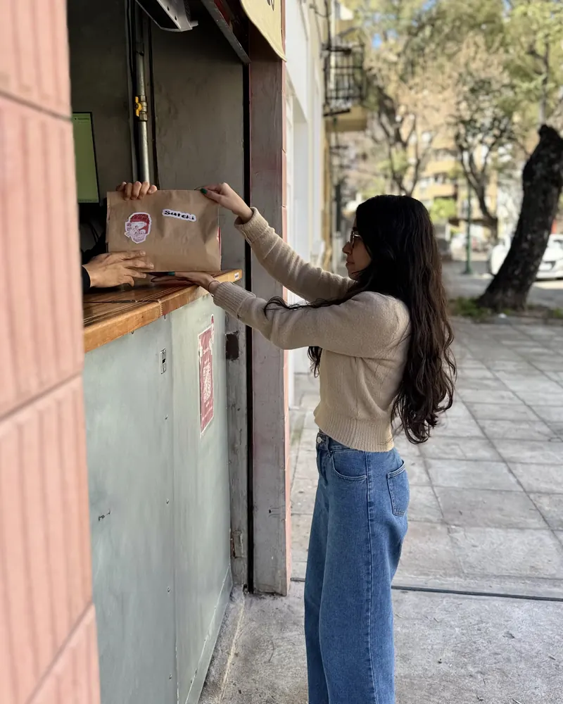Una clienta retira su pedido por la ventana de Suteki Pocitos